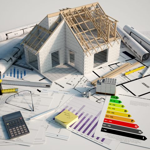 3D renderin of a house under construction on top of blueprints, mortgage forms and a energy efficiency chart